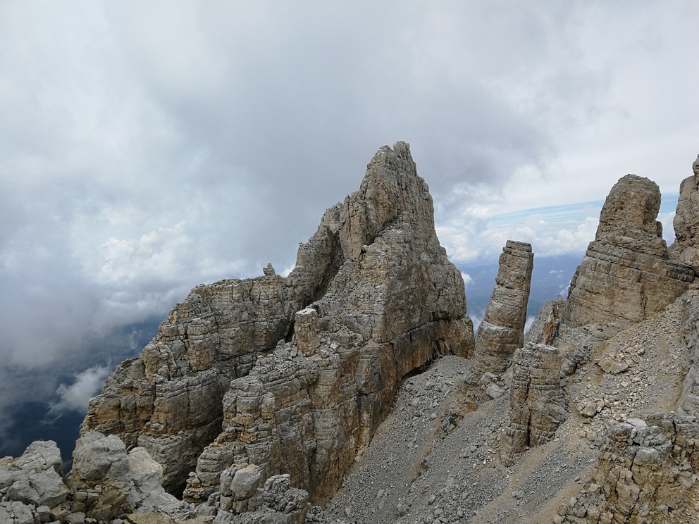 Latemar: catena montuosa, rocce chiare con cielo nuvoloso. Si vede la Torre di Pisa: una roccia un po' storta.