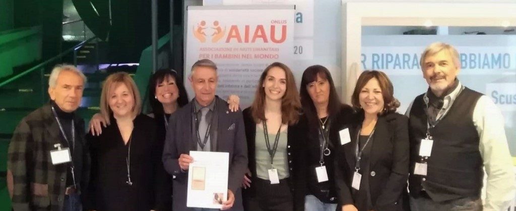 Volontari AIAU Onlus con Elena di PRG, uomini e donne davanti al roll-up AIAU.