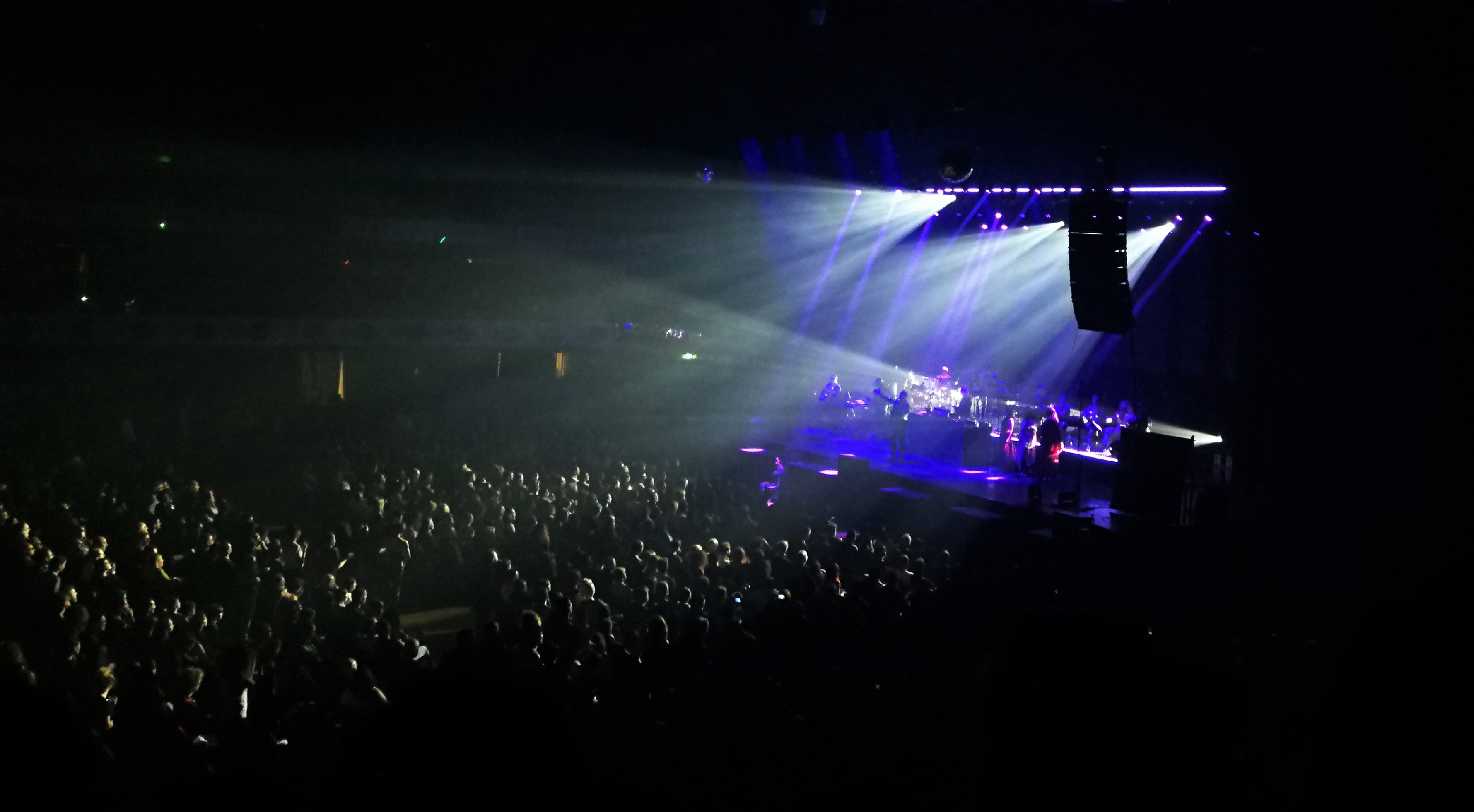 Palco con riflettori e pubblico parzialmente illuminato.