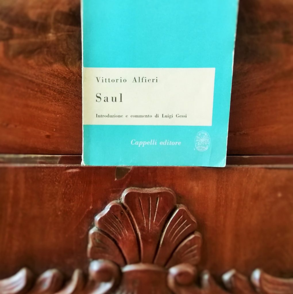 La copertina del libro con sfondo un legno scuro e caldo con venature, sotto una decorazione floreale dello stesso legno.