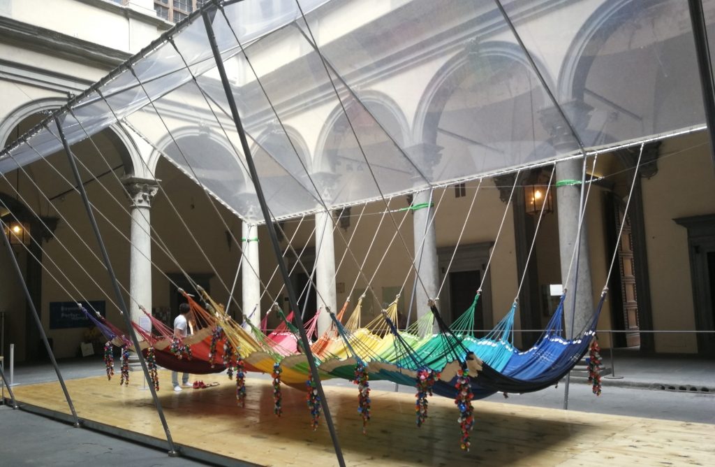 Cortile di Palazzo Strozzi con l'istallazione: un insieme di amache colorate.