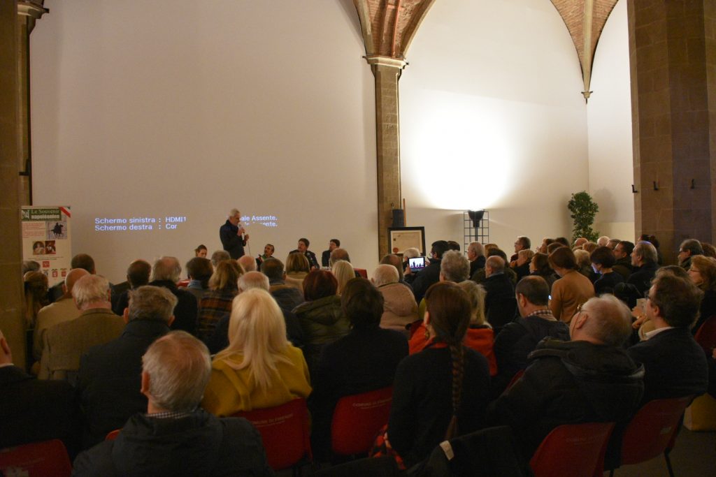 Intervento di uno dei relatori con il pubblico visto di spalle.
