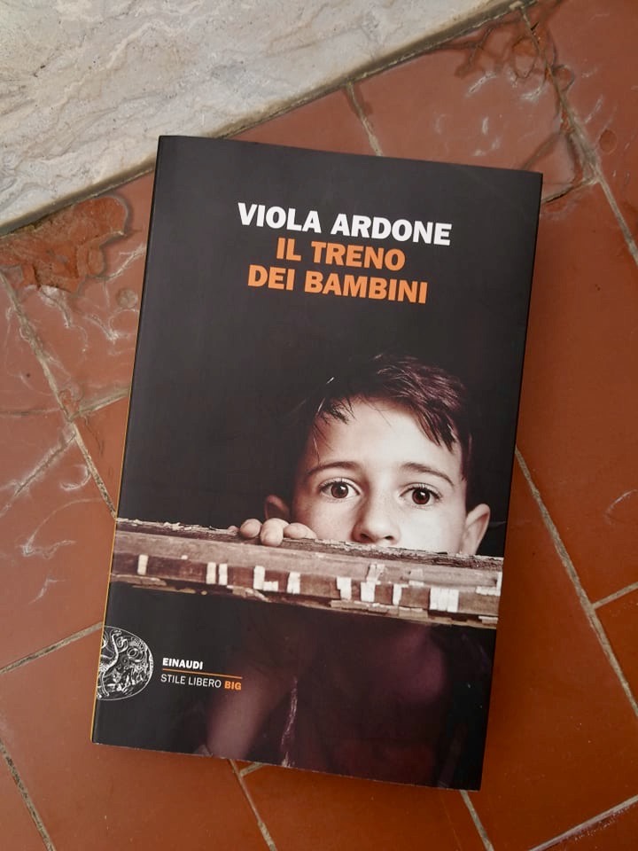 Copertina del libro Il treno dei bambini su mattonelle rosse.