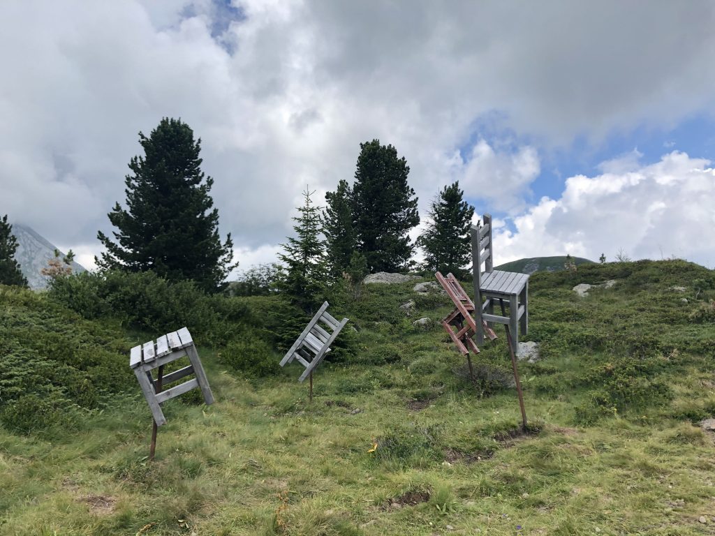 L'opera di Doliana nel contesto del prato verde con alberi sullo sfondo.