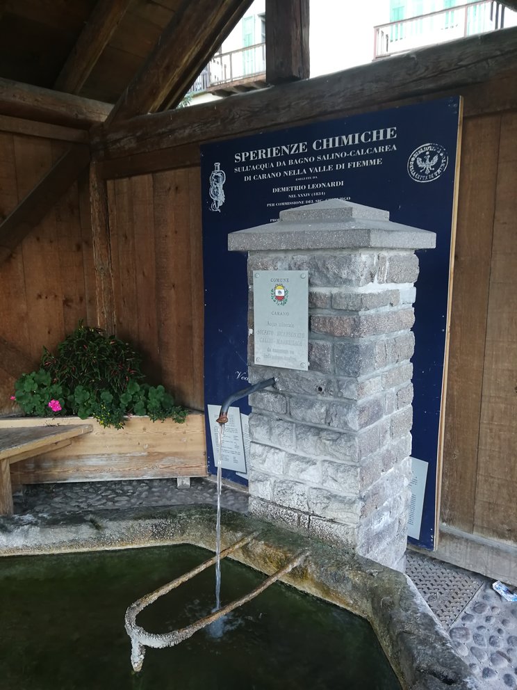 Fonte di acque termali con cannella e pannello esplicativo.
