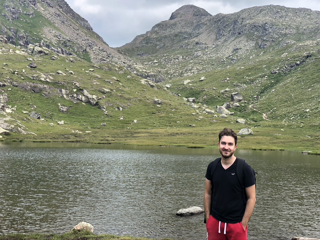 Lorenzo sulle sponde del lago Lusia; verde dei prati e rocce.