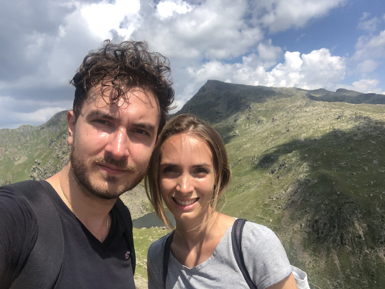 Federica e Lorenzo sulle sponde del lago Lusia; verde dei prati e rocce.