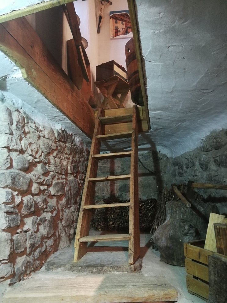 Scala con apertura sulla cucina, sotto la cantina con mura bianche e pietra.
