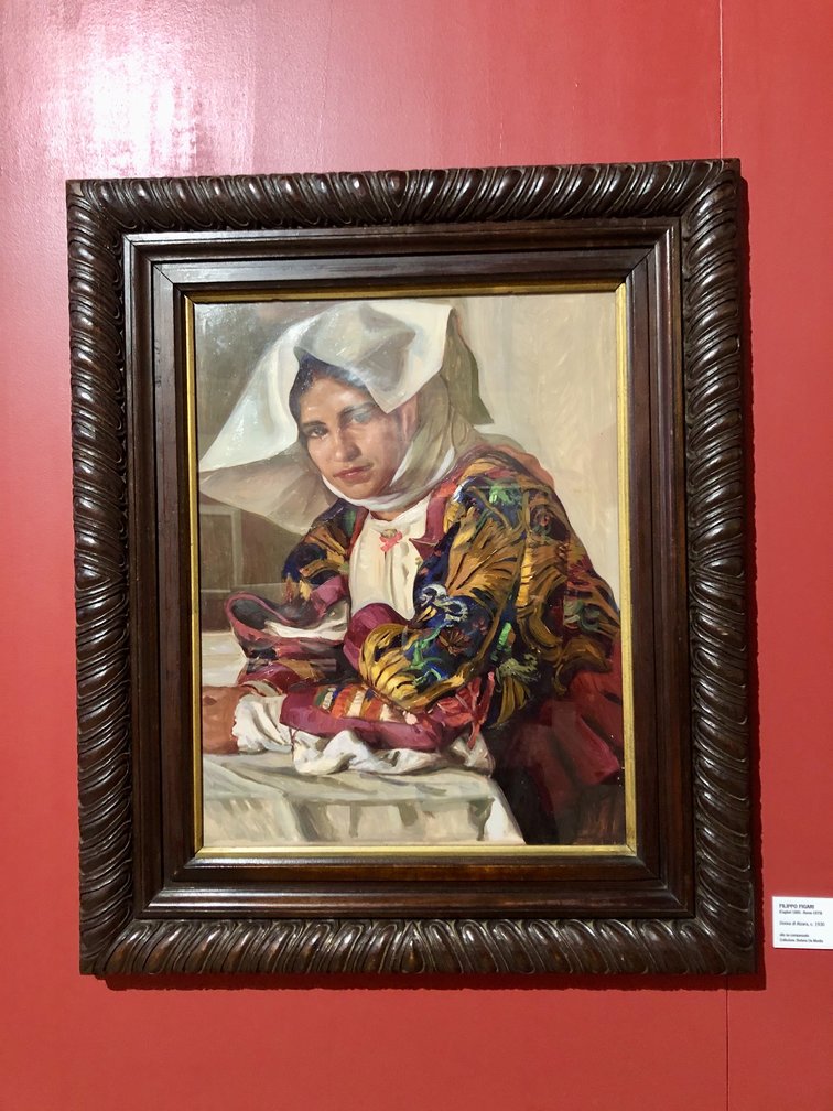 Quadro con donna in abiti tradizionali sardi e capo coperto da velo bianco.