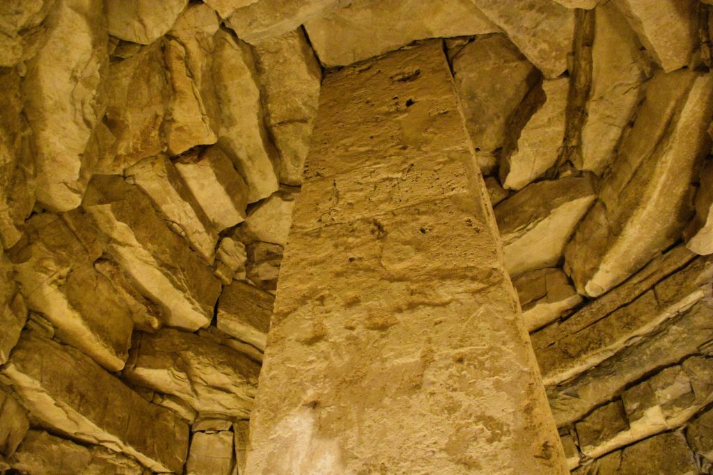Soffitto della finta cupola con massi e pilastro enorme centrale.