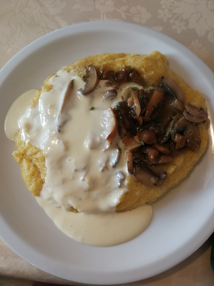 Polenta con formaggio fuso e funghi.