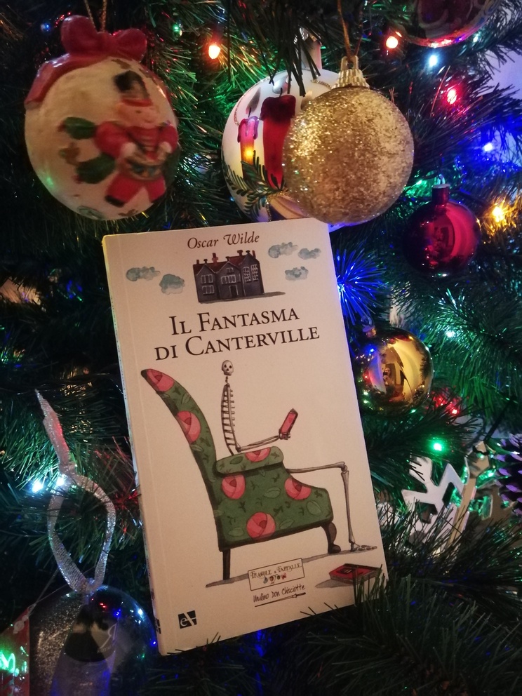 Copertina del libro Il fantasma di Canterville sull'albero, accanto a luci e palline.