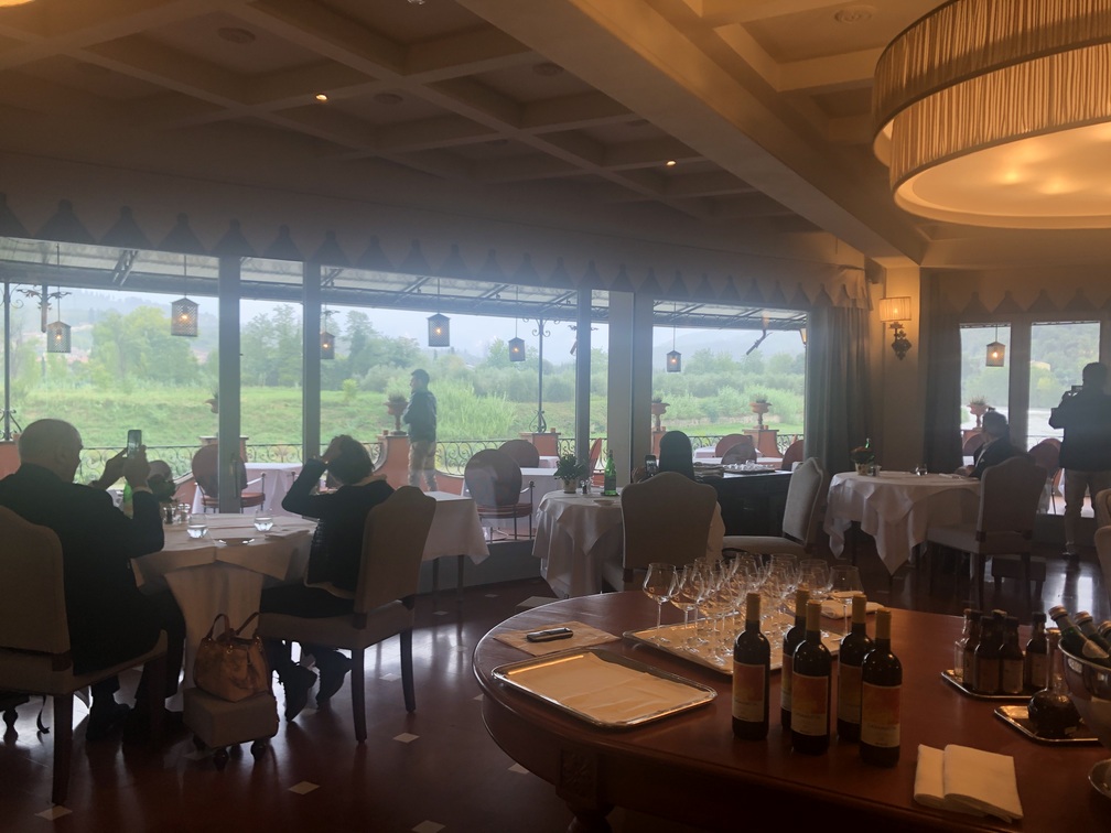 Villa La Massa - Ristorante Il Verrocchio, interno con tavoli e vetrate su vegetazione.