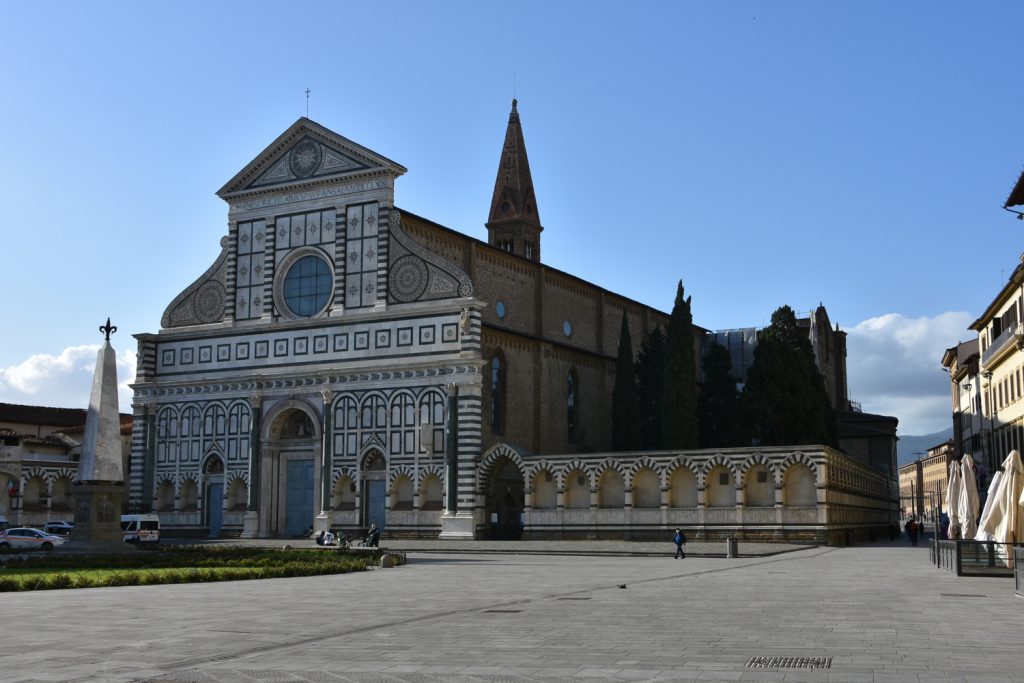 Santa Maria Novella - facciata della chiesa con obelisco nella piazza, alberi e cielo azzurro.