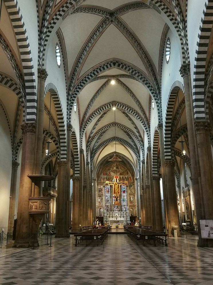 Santa Maria Novella - interno con navate, archi a sesto acuto, sedie e il crocifisso al centro.