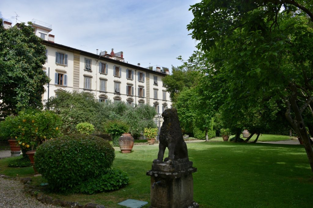 Palazzo Ximenes Panciatichi - giardino verde e statua di un leone.