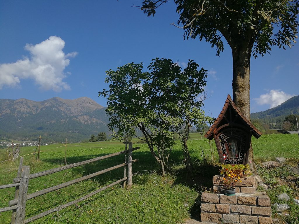 Edicola con prati e montagne.