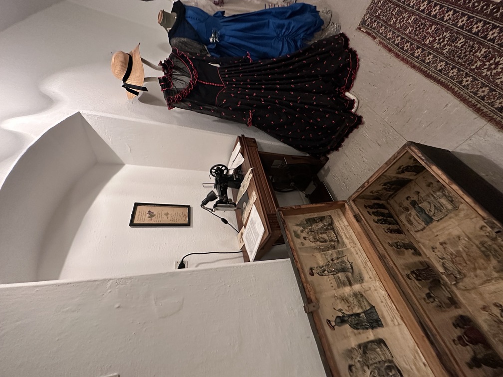 Museo della Cultura Popolare di Egna - baule, vestiti e macchina da cucire.