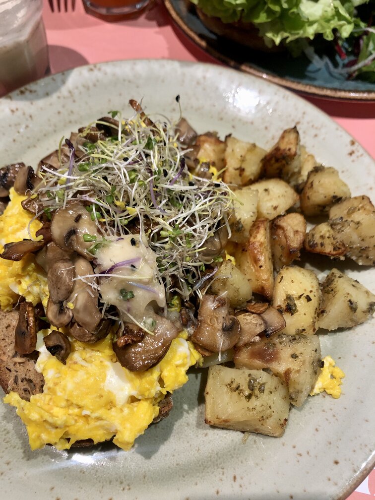 Shake Cafè a Firenze - uova strapazzate su pane rustico senza glutine con germogli, funghi e patate arrosto, condito con olio al tartufo.