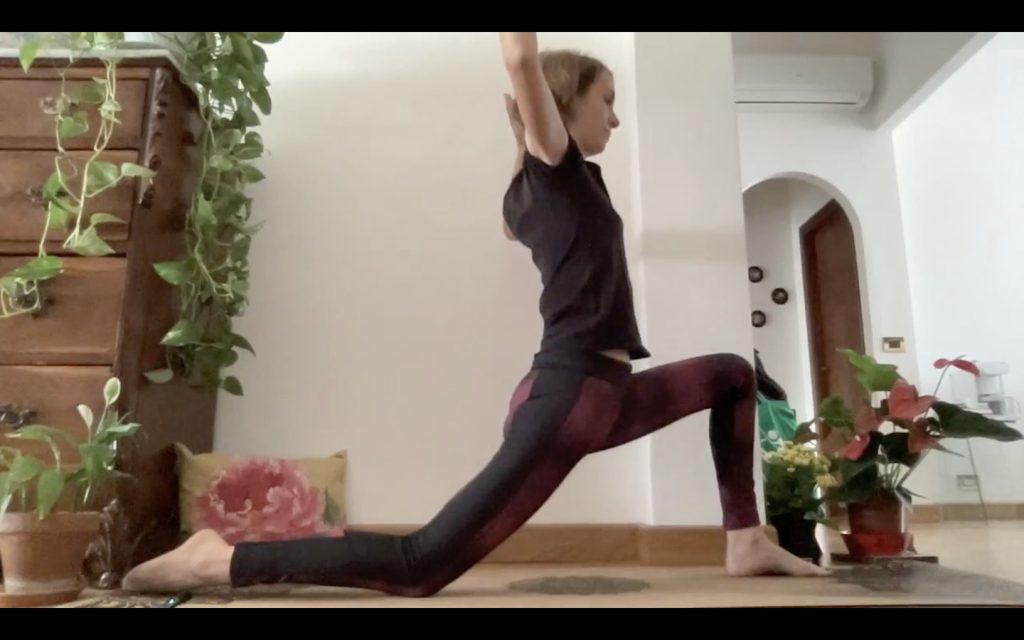 Pratica yoga - affondo con braccia aperte di lato.