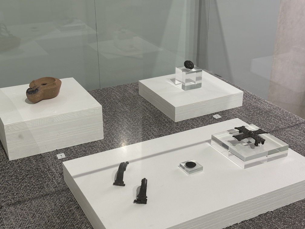 Reperti provenienti da Cavalese, loc. San Valerio, Ufficio beni archeologici - Provincia autonoma di Trento
1. Lucerna ad olio, Età romana, Il secolo d.C., ceramica 2. Fibule tipo Aucissa, Età romana, I secolo d.C., bronzo 3. Moneta follis ridotto, Età romana, 324 - 327 d.C., bronzo 4. Fibula a croce, Età altomedievale, VI - VII secolo d.C., bronzo 5. Fibula a disco di produzione slava con raffigurazione di Agnus Dei
Età medievale, X secolo d.C., bronzo e smalto.