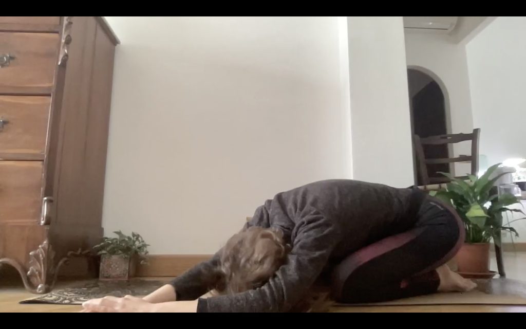 Yoga - Balasana, posizione del bambino con variante di allungamento laterale.