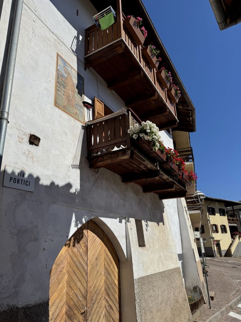 Carano, Ville di Fiemme - via dei Portici con affresco di Sant’Antonio Abate.