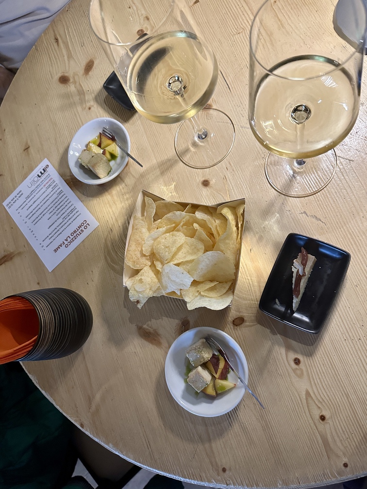 El Molin Winebar&bistrot di Cavalese - aperitivo con due bicchieri di vino bianco, patatine, pecorino sardo con confettura di fichi e insalatina di pesche e tofu.