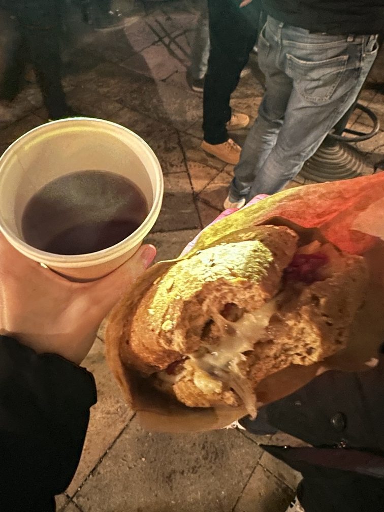 Villaggio sotto l'albero - Mercatino di Natale 2025 di Predazzo; grog alla ciliegia e panino vegetariano dello stand Non solo fumo di Panchià.