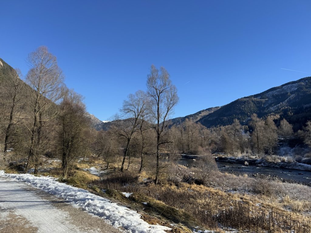 Sentiero e ciclabile lungo il torrente Avisio - veduta sui pendii boscosi della catena del Lagorai.