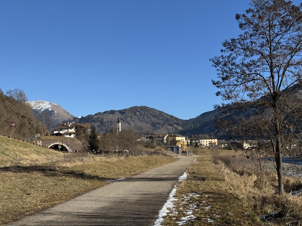 Sentiero e ciclabile lungo il torrente Avisio - veduta su Ziano, con il campanile della chiesa.