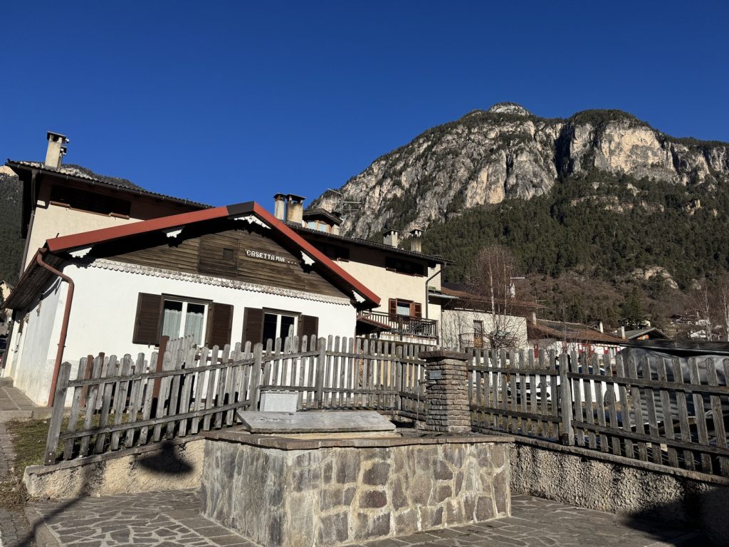 Panchià - fontana e abitazioni in via Cavelonte, con il Monte Cornon o Cornacci sullo sfondo.