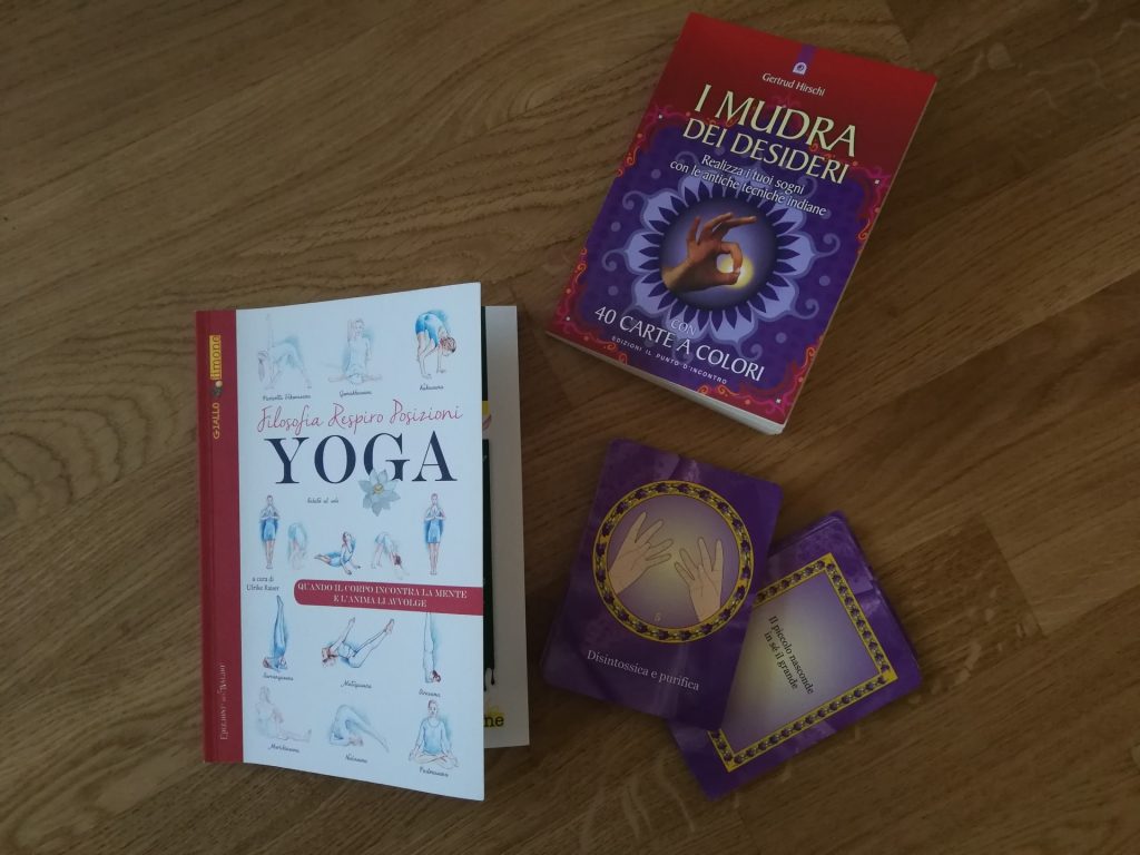 Due libri dedicati allo yoga e ai mudra con alcune carte.
