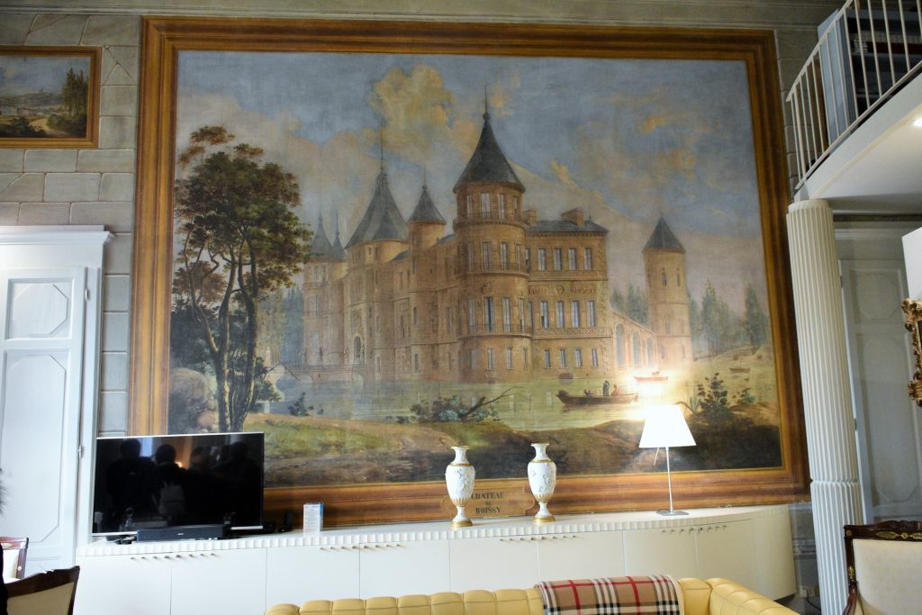 Interno della villa: un salotto con un dipinto di un castello francese.