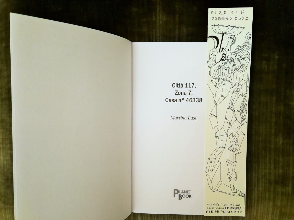 Prima pagina del libro, con il titolo, autrice e casa editrice; accanto un segnalibro in carta con disegni e dedica.