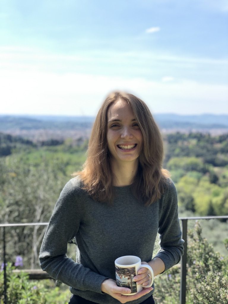 Federica sorridente con tazza di tè un mano, sullo sfondo colline e Firenze.