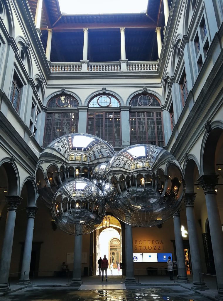 Cortile di Palazzo Strozzi con l'installazione di tre palle di metallo riflettenti.