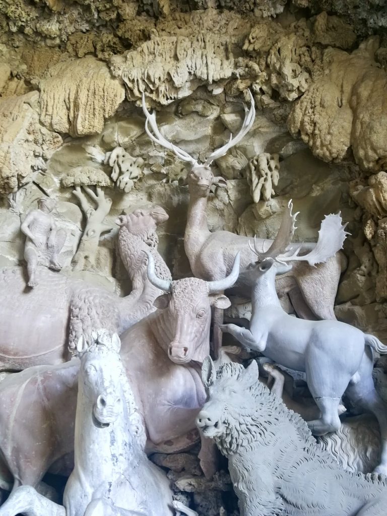 Statue di vari animali all'interno di grotta con spugne.