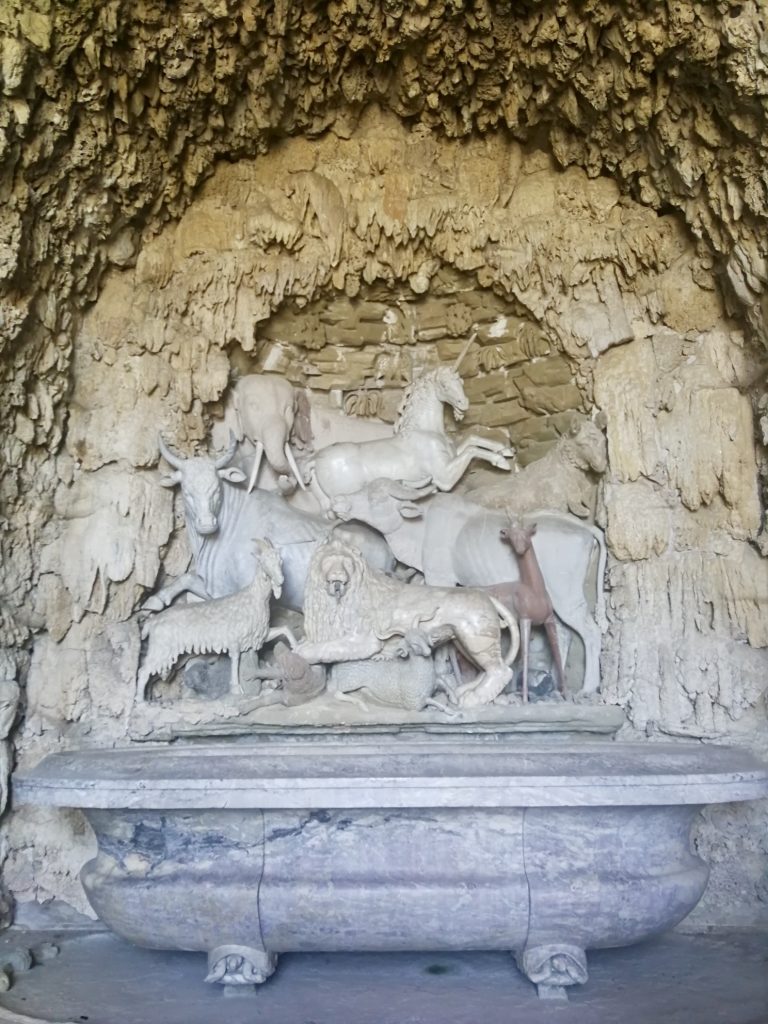 Statue di animali dentro grotta di spugne, sopra una vasca.