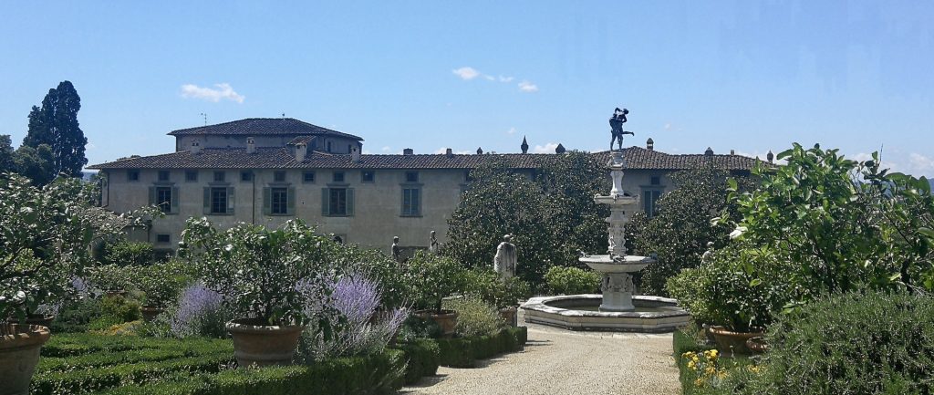 Giardino all'italiana con agrumi e prati, una fontana al centro e sullo sfondo la villa.