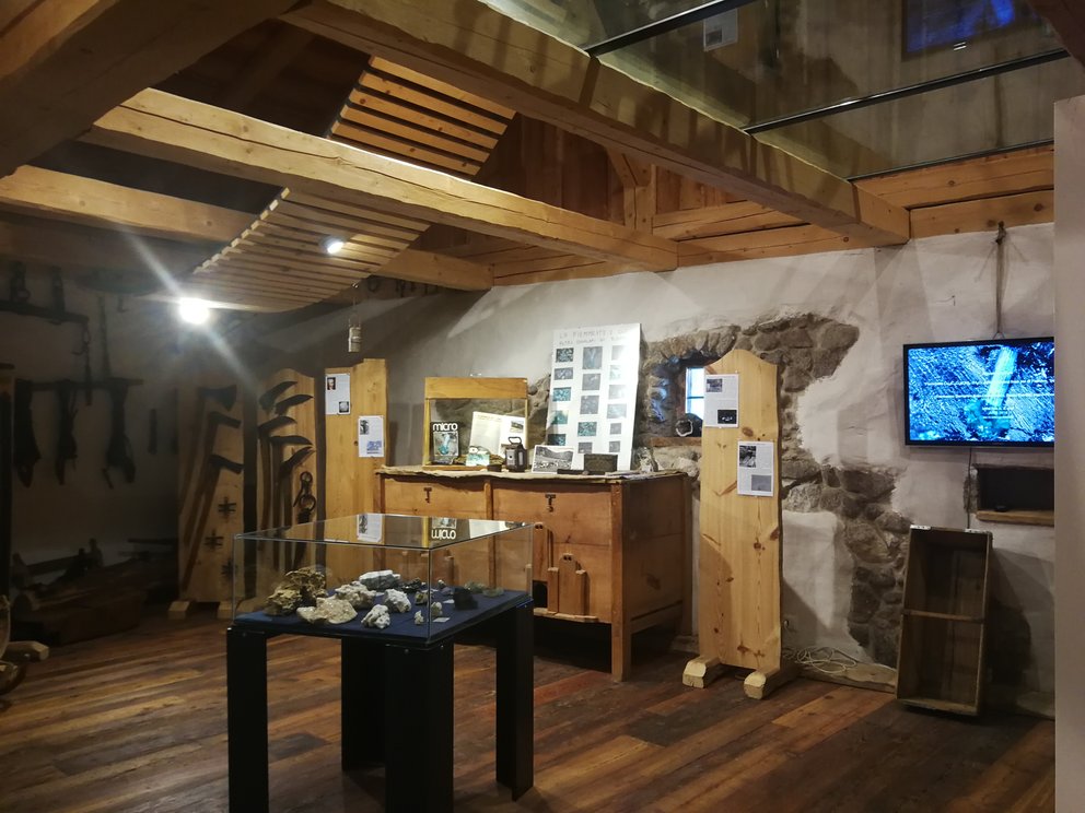 Museo di Carano: fienile con mostra sui minerali, tv e bacheche di esposizione.