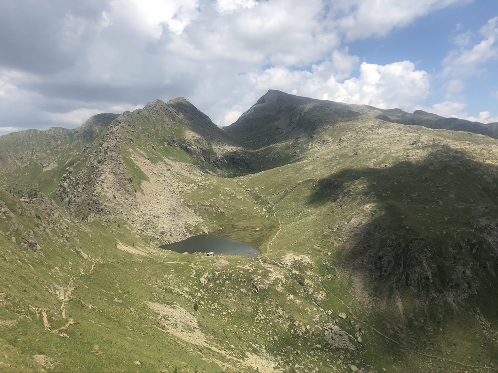 Laghi di Lusia e panorama sulle catene montuose; verde dei prati e rocce.