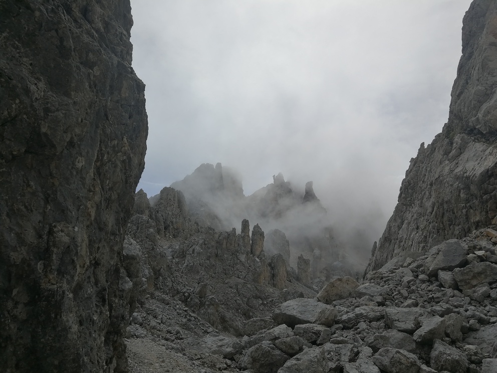 Latemar: catena montuosa, rocce chiare con cielo nuvoloso. Nuvole che coprono anche la roccia.