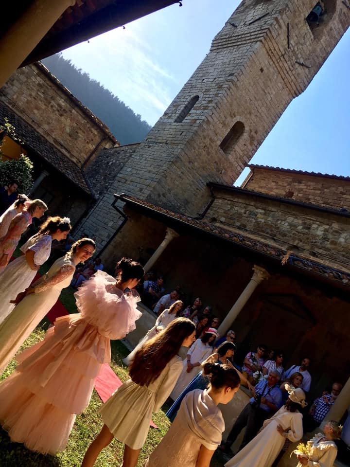Chiesa di Sant'Andrea a Cercina - chiostro durante un evento; porticato con colonne e parte del campanile; persone vestite con abiti da sposa per una siflata.