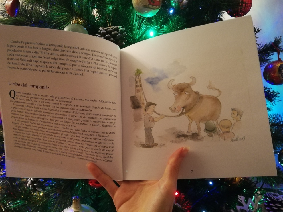 Interno del libro Le parcandole di Carano con una pagina scritta e un'altra con un'immagine disegnata con un toro al guinzaglio.