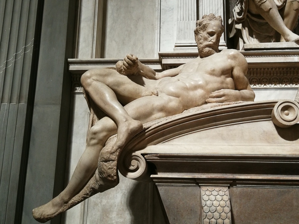 Cappelle Medicee: il Crepuscolo di Michelangelo: figura maschile, sdraiato, nudo, muscoloso, guarda verso il basso.