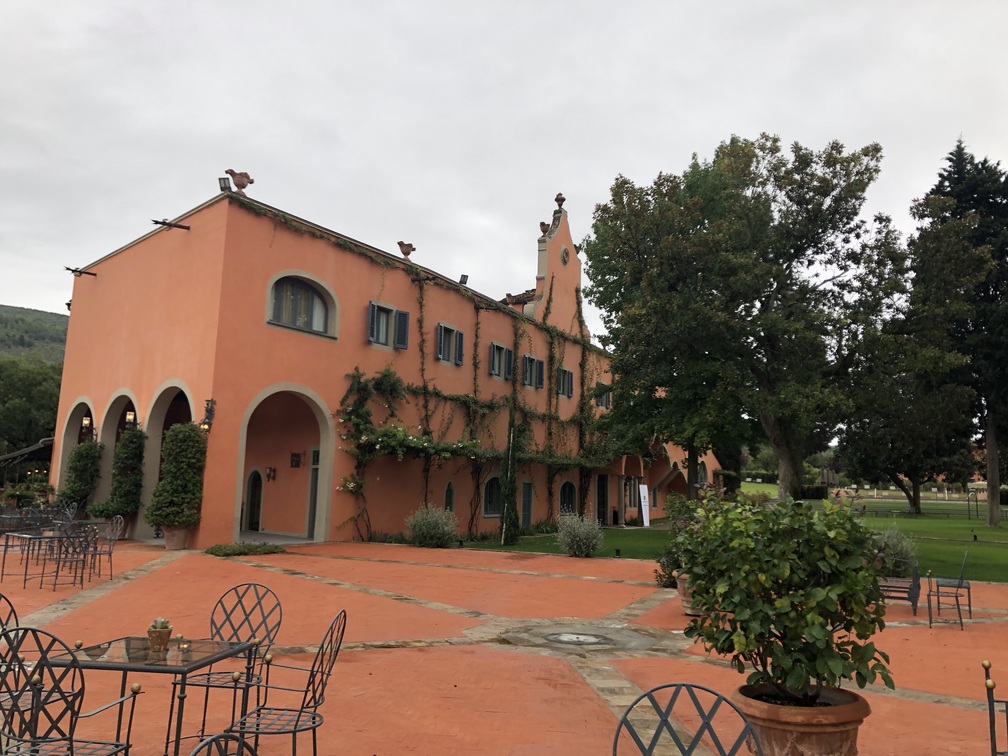 Villa La Massa: terrazza, alberi ed edificio rosso.