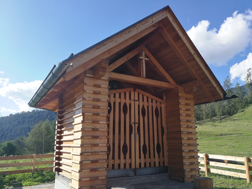 Chiesetta degli Alpini - l'entrata in legno con tetto spiovente e cancello.