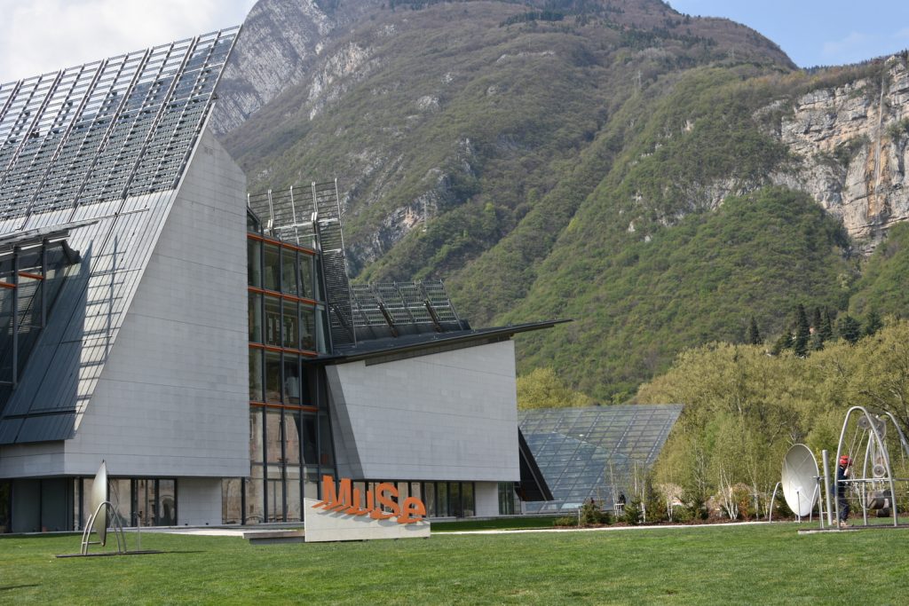 Muse: struttura moderna con vetri e dietro alberi e montagne.
