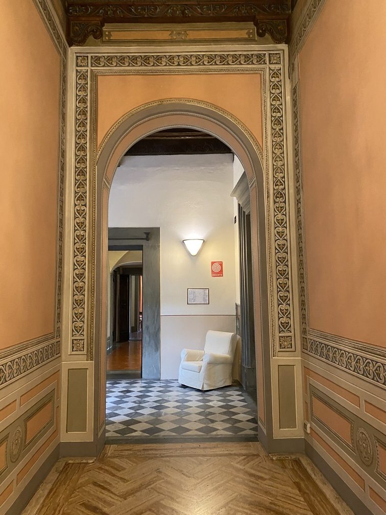 Villa Castelletti - interno di un corridoio con alcune decorazioni recenti, geometriche, pareti rosate.